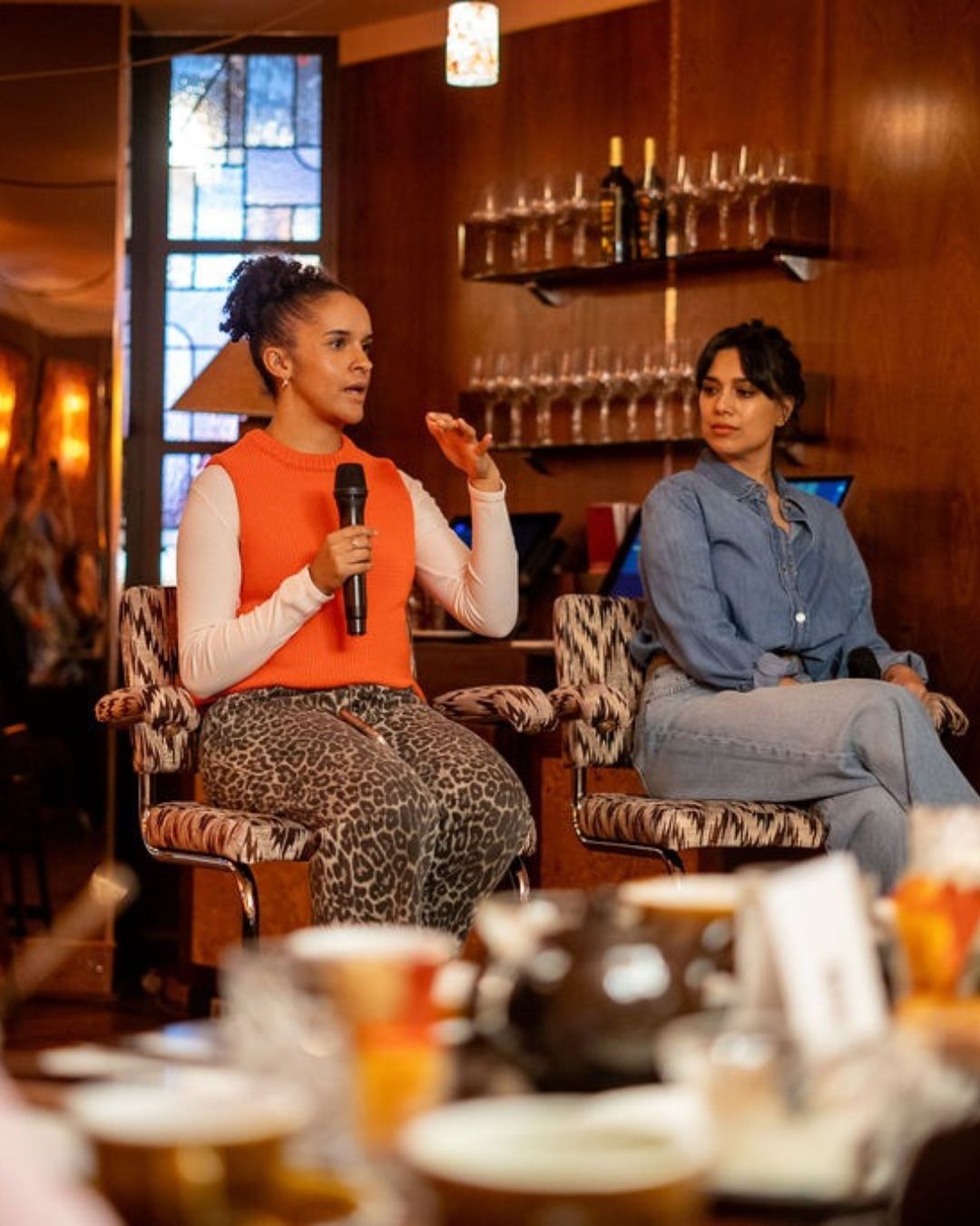A panellist speaking to the room while another listens