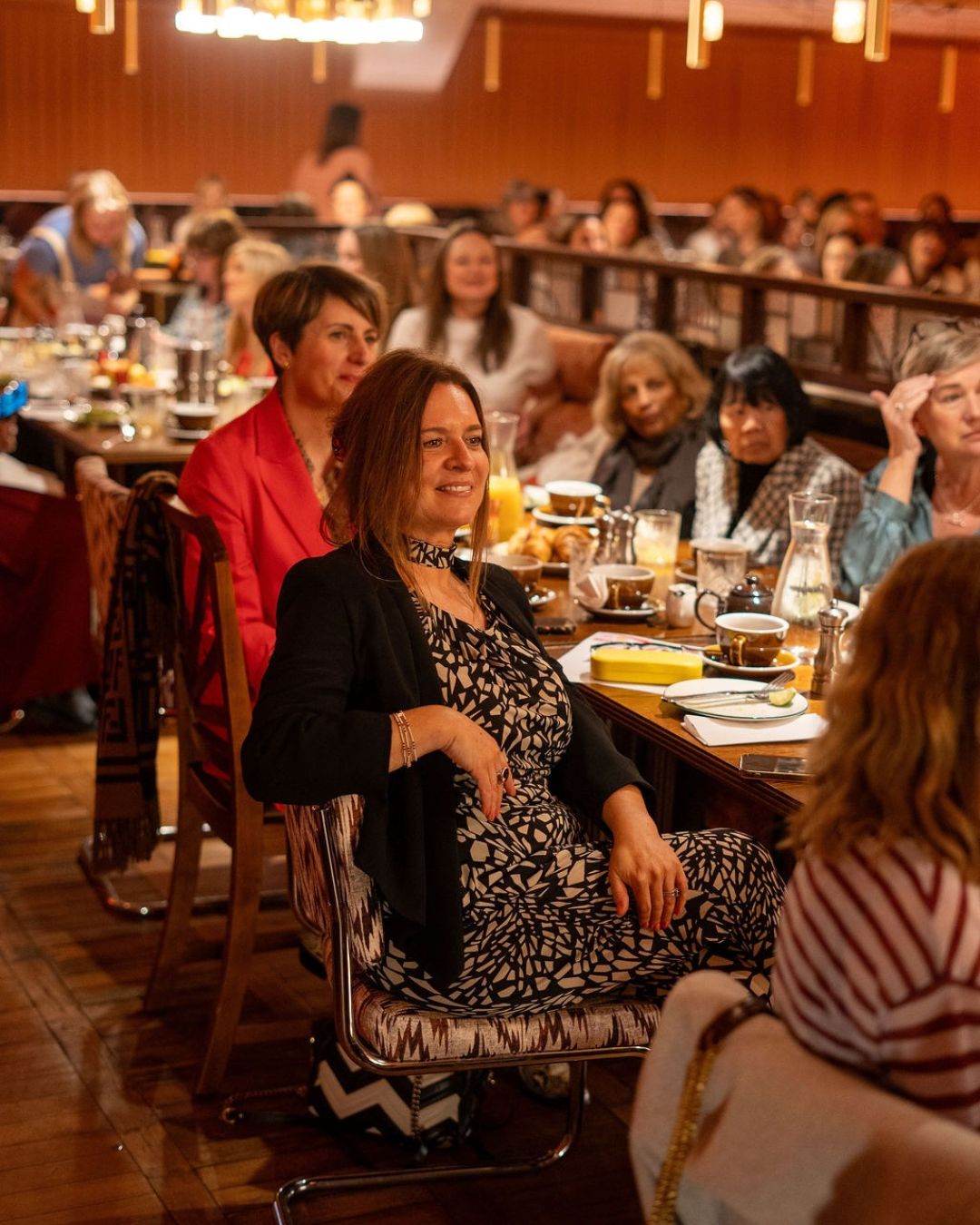 Guests seated at long breakfast tables filling the room at Cosy Club, St Albans