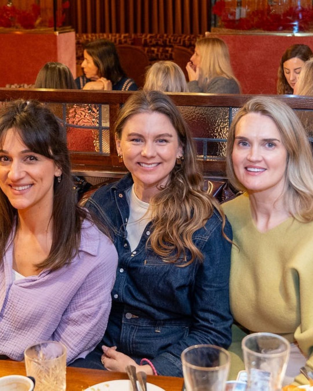 Three guests smiling side by side at the breakfast
